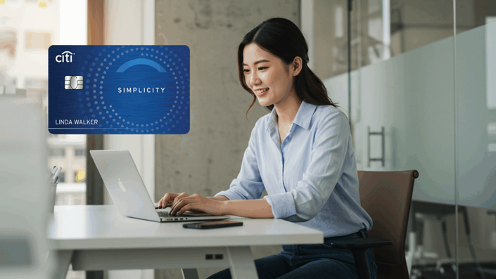 Smiling woman working on a laptop at a desk, with a Citi Simplicity credit card shown prominently in the foreground.