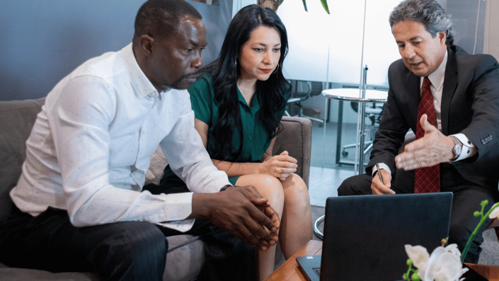 A financial advisor explaining AI integration in personal finance to a couple, highlighting AI-powered investment strategies.