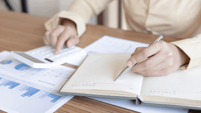 Person sitting at a clean, organized desk looking relieved while reviewing a single, simplified financial statement after successful debt consolidation.