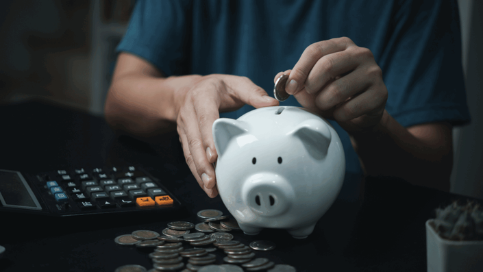 Piggy bank with coins and a small plant growing, illustrating the importance of consistent saving to prevent Retirement Planning Mistakes.